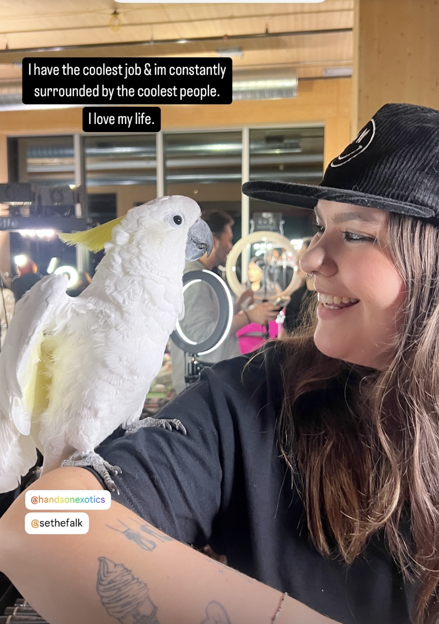 Photo of Mandy Sleep holding a cockatoo. 