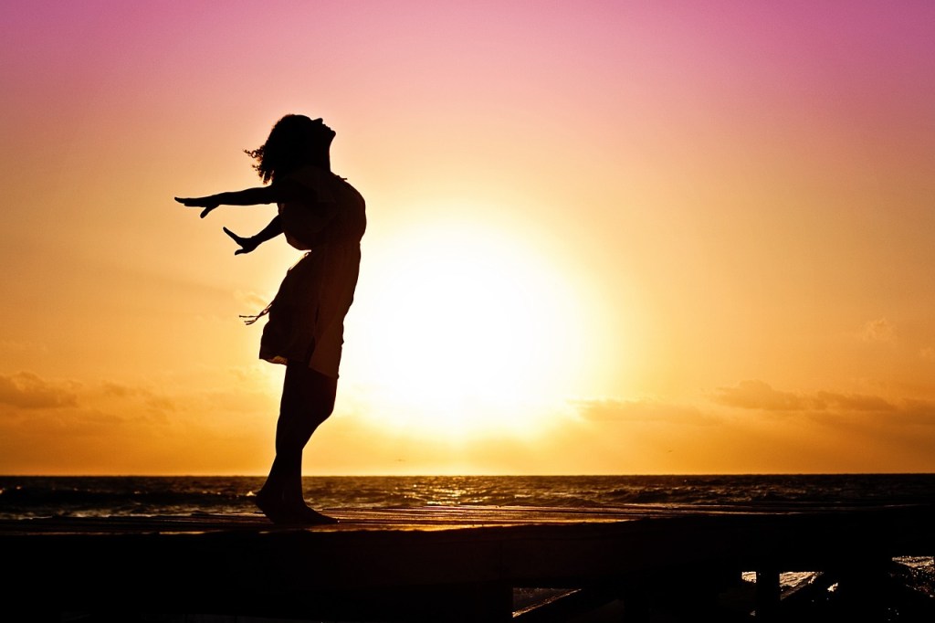 Woman free in sunset.