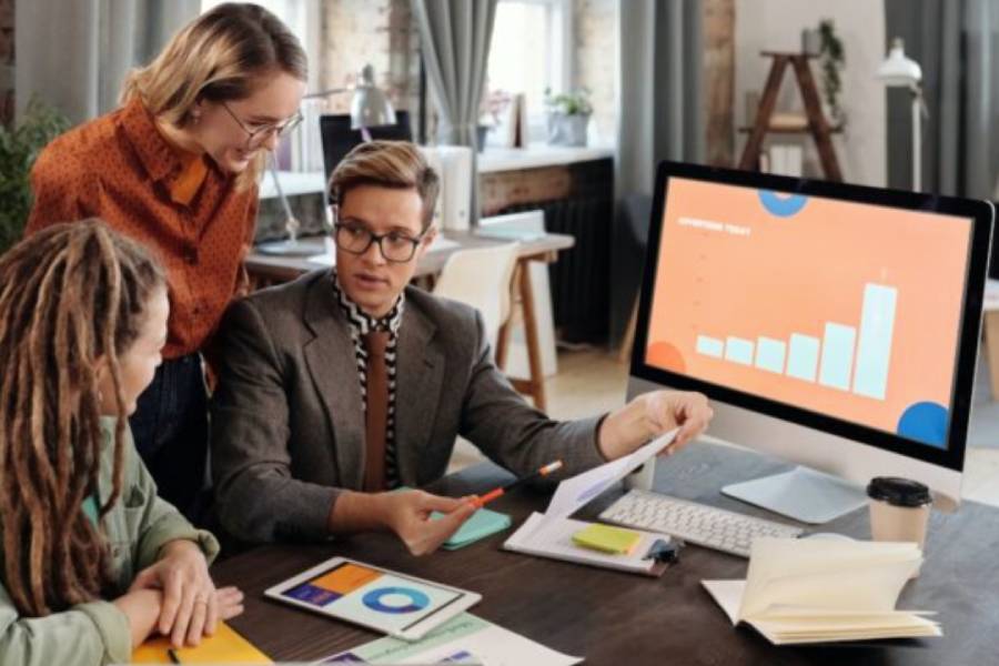 Three people are discussing and analyzing data together.