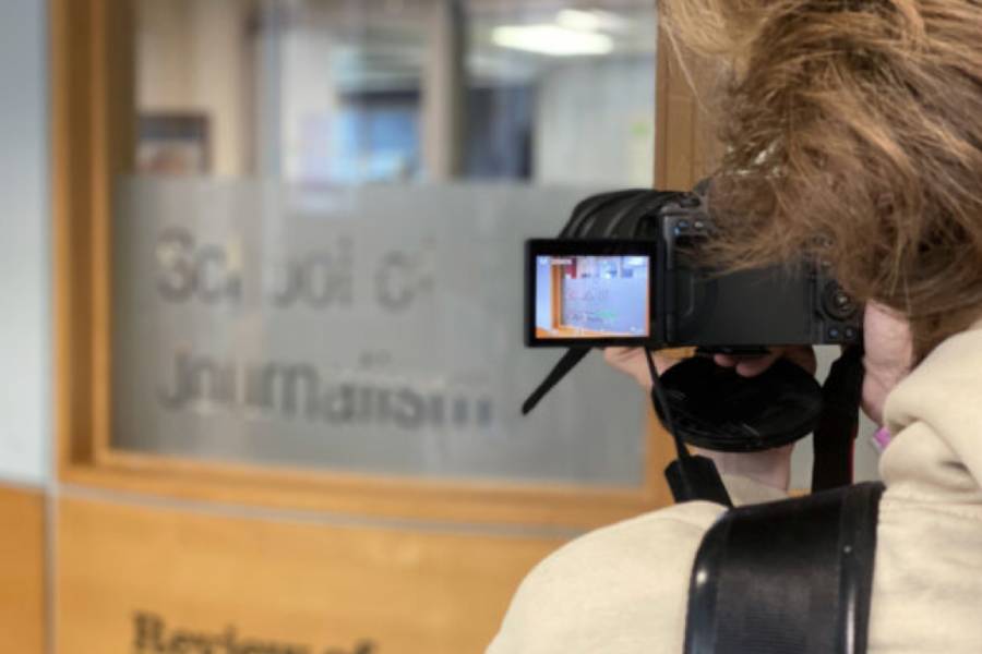 A picture taken of someone taking a photo of the School of Journalism.